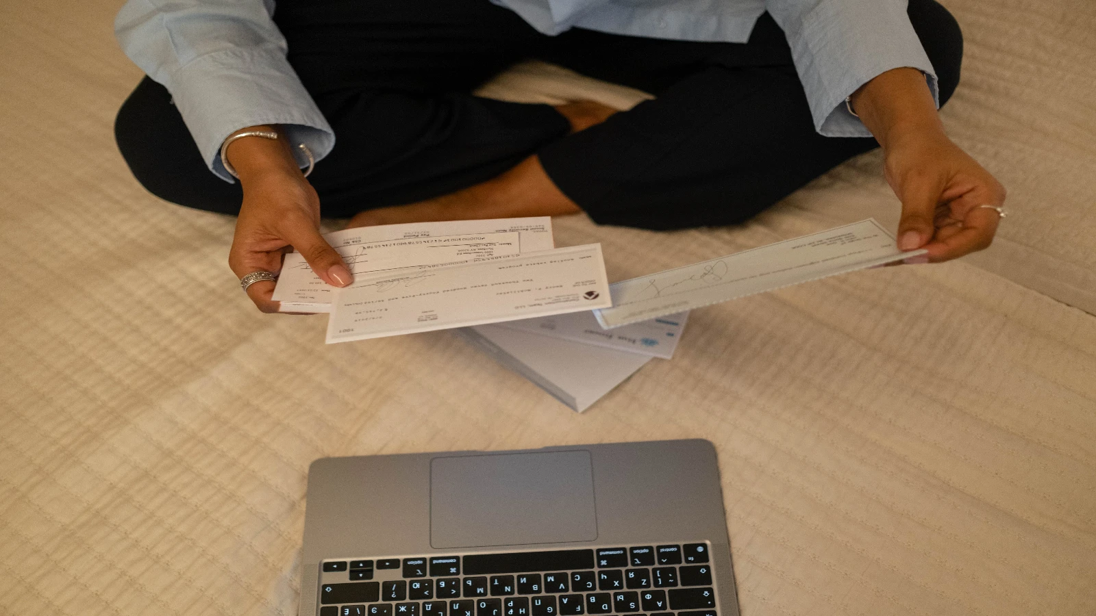 Como abrir um MEI: empreendedora organiza documentos financeiros ao lado de um computador