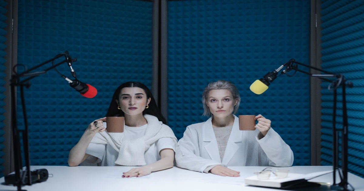 mulheres diante de microfones ilustram análise sobre clonagem de voz por inteligência artificial