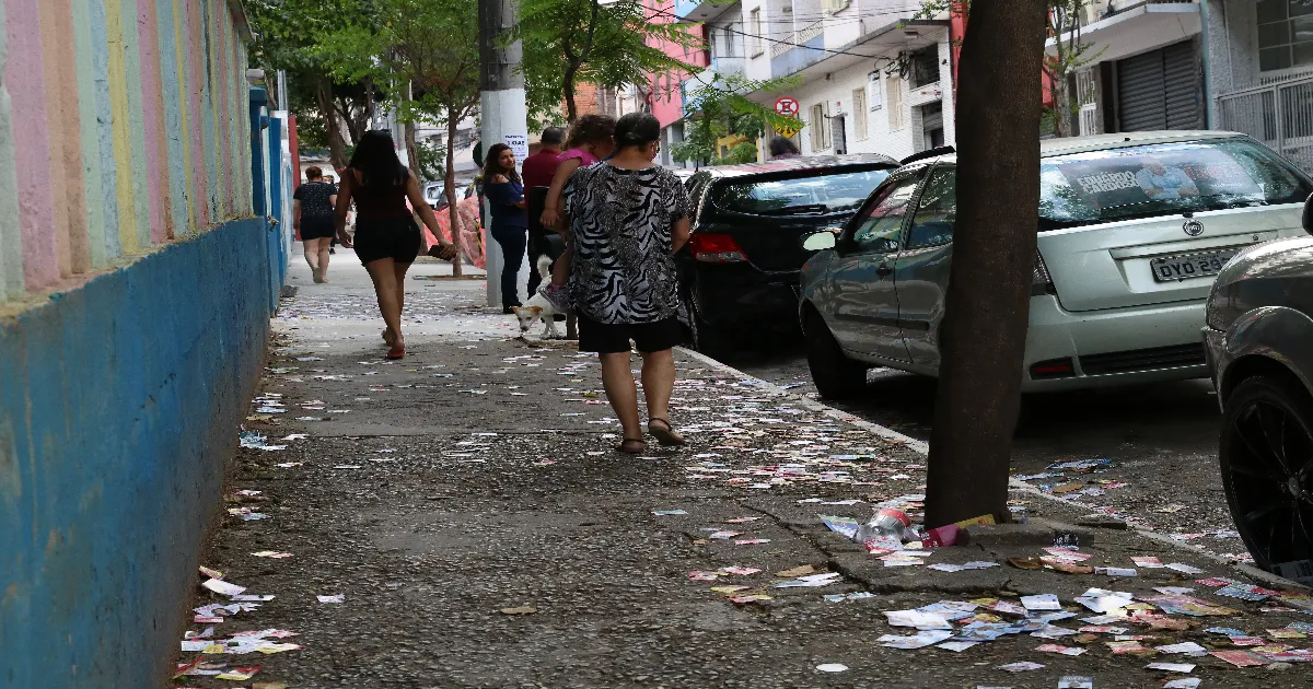 Propaganda eleitoral 2026 com santinhos espalhados em calçada após eleição